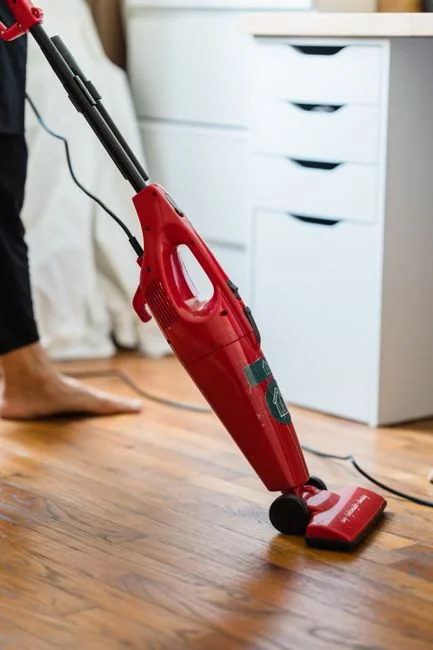 Une femme de chambre dispose des coussins dans une chambre d'hôtel somptueuse, mettant en avant le confort et le raffinement.